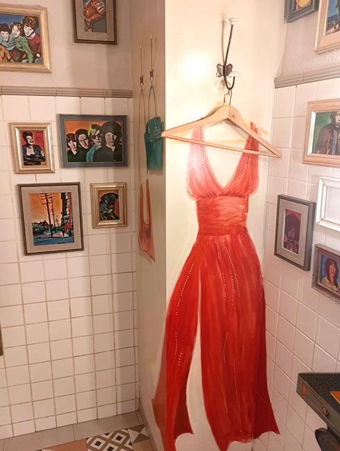 Pared interior con percha y trampantojo de vestido de mujer sobre ella