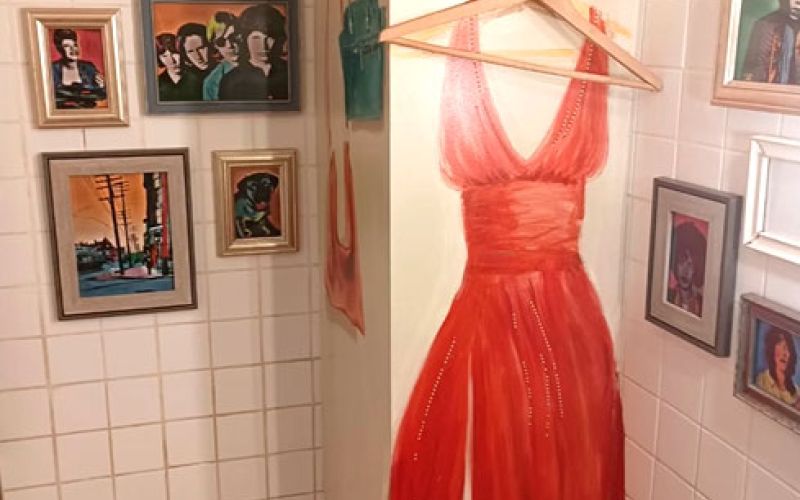 Pared interior con percha y trampantojo de vestido de mujer sobre ella